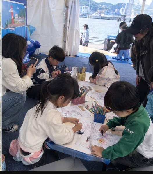 트라이애슬론광장 입구에서 축제 안내판을 확인하는 가족 방문객 모습
